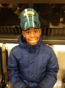 Tavares, 9, anxiously waits at the Flint, MI Amtrak station wearing a Jr. Conductor hat